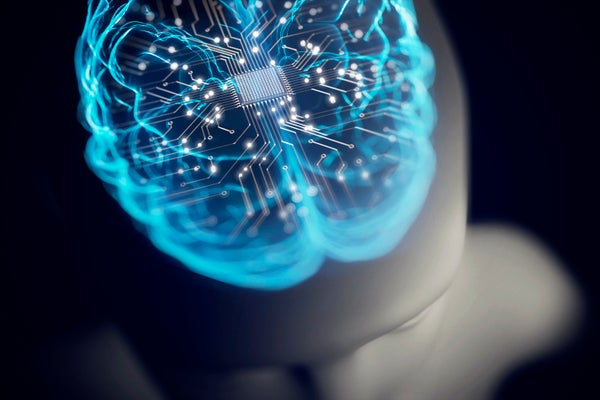 Artist concept of a circuit board in the shape of a brain along with a blue image of a brain overlaid on top of a colorless human-like robot figure on a black background