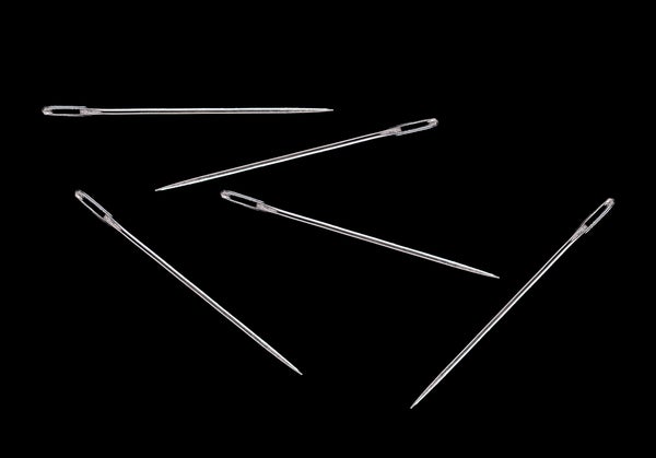 Five sewing needles on black background