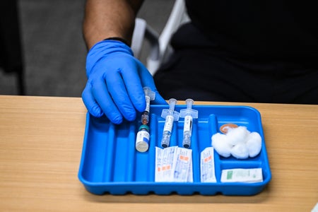 Blue plastic tray containing vaccine supplies