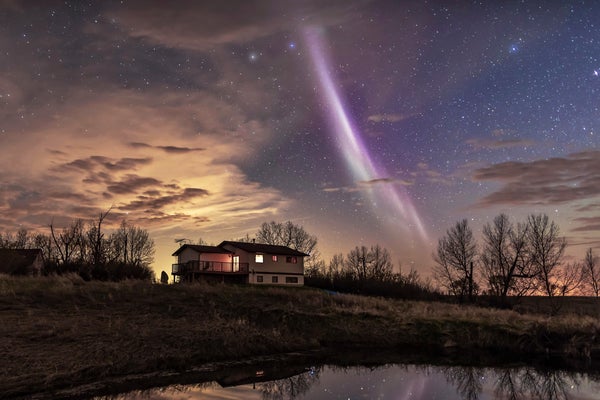 A streak of whitish light across a night sky